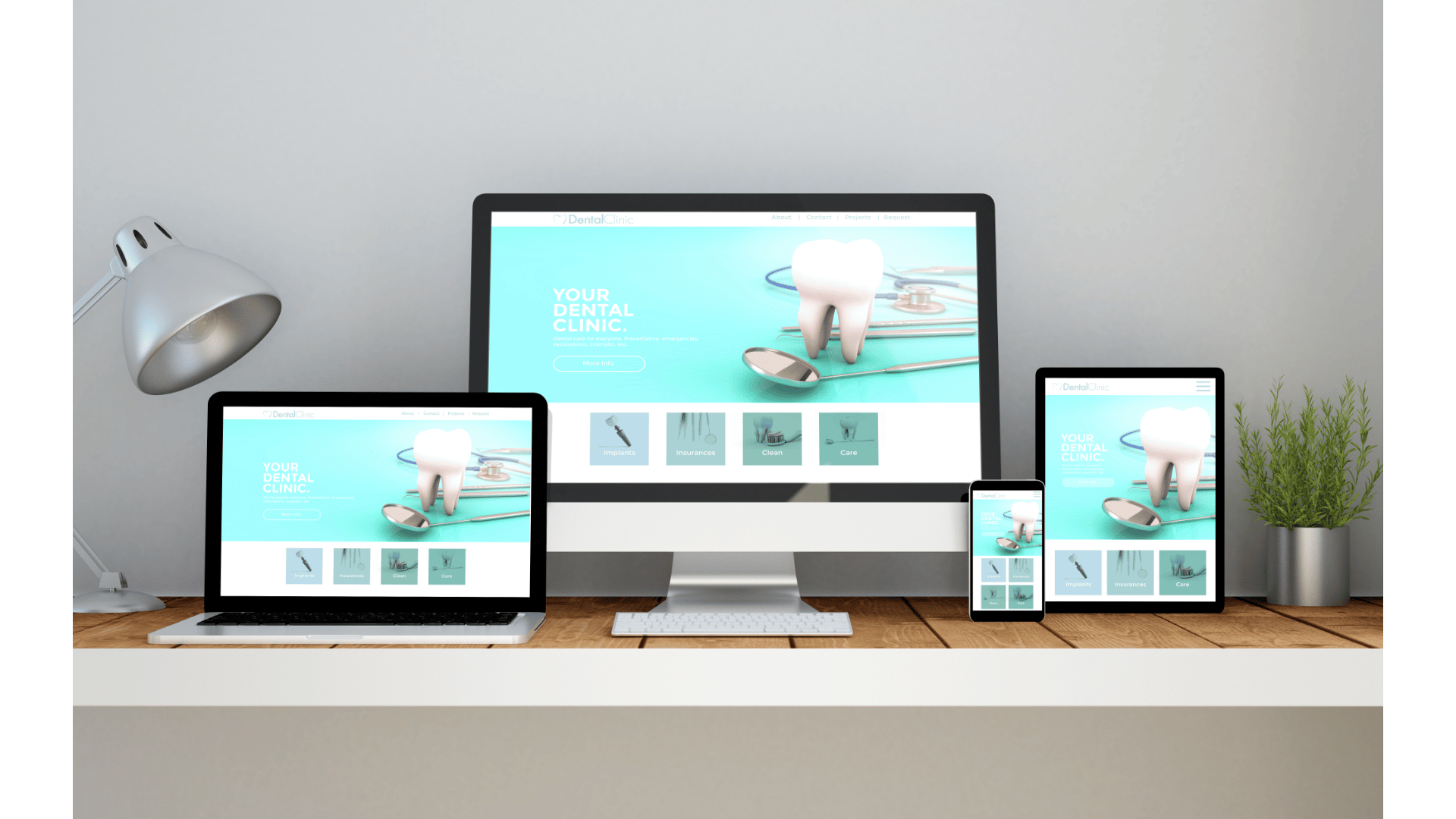A desktop monitor, laptop, tablet, and phone on a wooden desk, each displaying the same demo website design